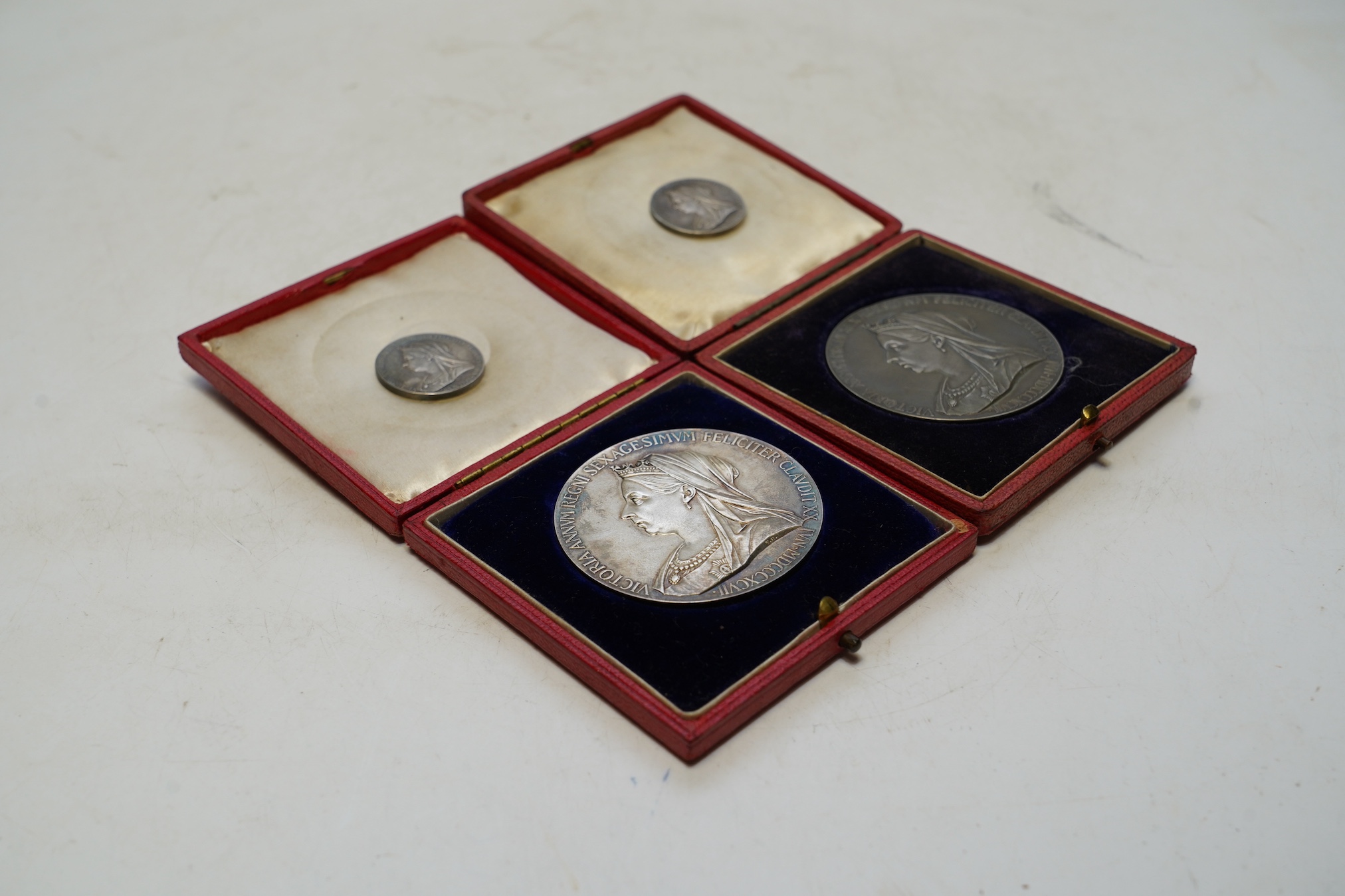 Two Victoria 1897 Diamond Jubilee commemorative silver medals, cased, and two smaller silver medals. Condition - fair